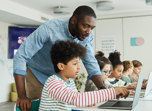 mentor working with child on computer